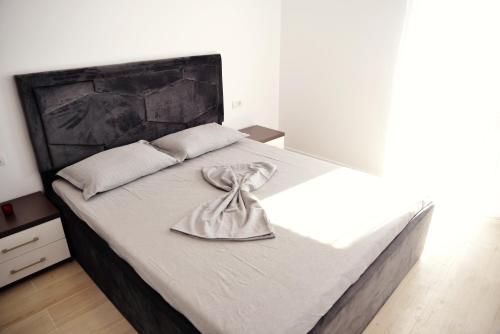 a bedroom with a large bed with a towel on it at Apartament Feeling Home în cartier WestResidence in Oradea