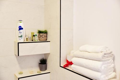 a pile of towels on a shelf in a bathroom at Apartament Feeling Home în cartier WestResidence in Oradea