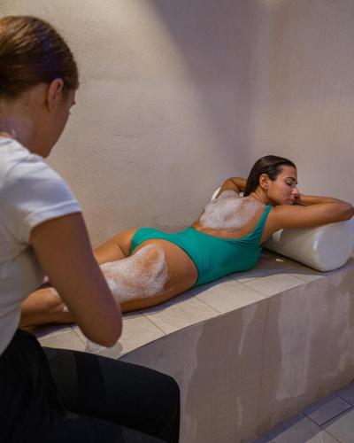 a woman in a bathing suit laying in a bath tub at Hotel & Spa Relais Freedom Club in Massa Lubrense