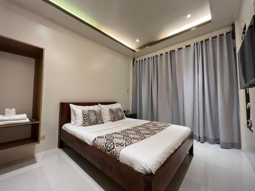 um quarto com uma cama e uma grande janela em Bulul Garden Resort em El Nido