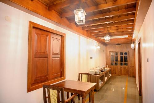 a dining room with a table and a counter at Surya Heritage Hotels in Kannur
