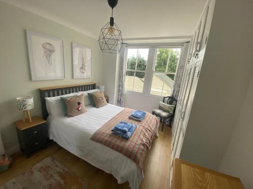 a bedroom with a bed and a window at Newton Croft Tenby overlooking North Beach in Tenby