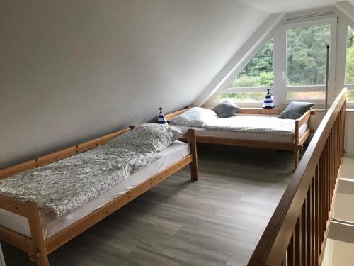 2 Betten in einem Zimmer mit Fenster in der Unterkunft Ferienwohnung Thedo in Bad Zwischenahn