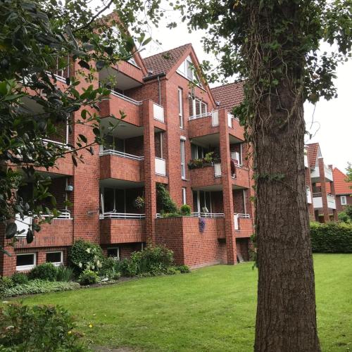 a large brick building with a green lawn in front of it at Ferienwohnung Thedo in Bad Zwischenahn