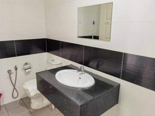 a bathroom with a sink and a toilet and a mirror at Mansion One Luxurious Seaview Vacation Homes in George Town
