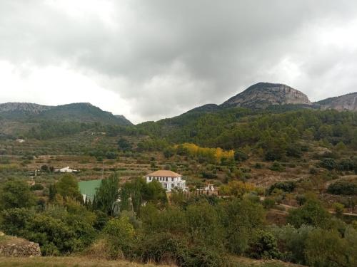 uma casa num vale com montanhas ao fundo em Habitacion de la marquesa em Alcoleja