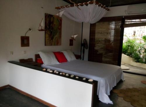 a bedroom with a bed with white sheets and a window at BELINTA plage STUDIO in Mahajanga