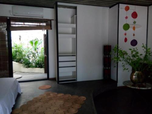 Habitación con dormitorio y puerta de cristal grande. en BELINTA plage STUDIO, en Mahajanga