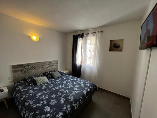 une chambre avec un lit et une fenêtre dans l'établissement Joli T2 Climatisé Nimes proche Gare et centre ville, à Nîmes