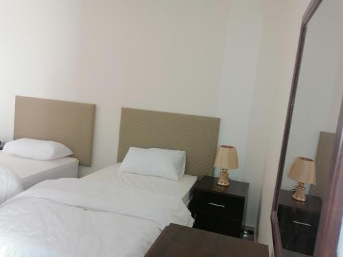 a hotel room with two beds and a mirror at Petra Guests home in Wadi Musa