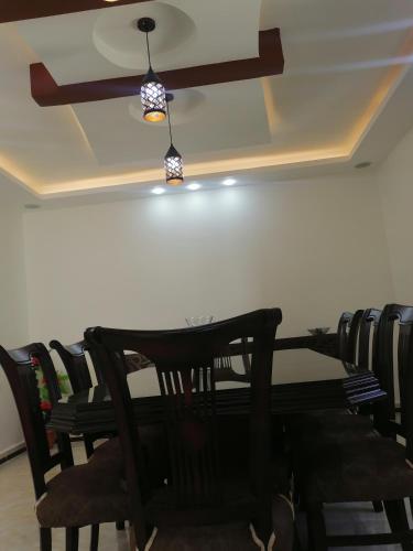 a dining room table with chairs and a ceiling fan at Petra Guests home in Wadi Musa