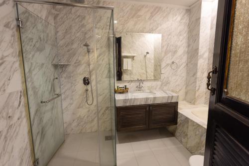 a bathroom with a shower and a sink and a tub at Hotel Puri Melaka in Melaka