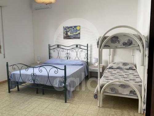 a bedroom with two beds and a canopy bed at Villa Tortuga By Cala Salento in Torre Lapillo