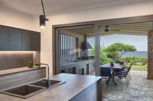 a kitchen with a view of a table and a dining room at DEVELIKIA PRIVATE VILLA 2 - Ierissos in Ierissos