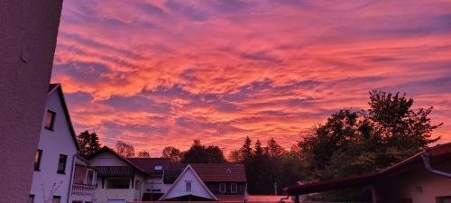 a sunset over a city with houses and trees at Zum Unstrut Radler in Helmsdorf