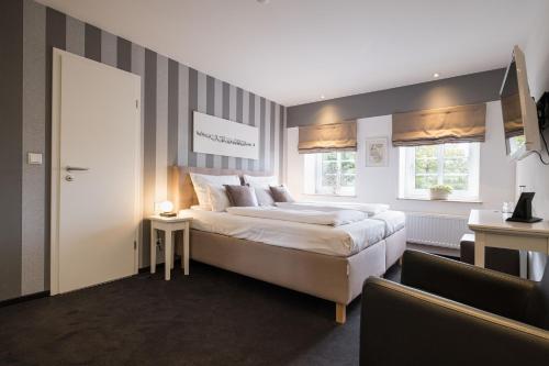 a large bedroom with a large bed and two windows at Eichhorns in Niebüll