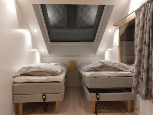 サーリセルカにあるKiisa A and B with aurora roomsの天井の小さな部屋のベッド2台