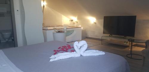 a hotel room with a bed with towels and a television at Alby suite in Termoli