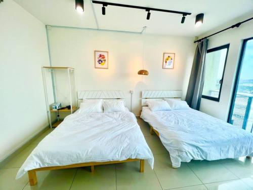 two beds sitting next to each other in a bedroom at D 1-5Pax Cozy Home Trefoil Setia Alam 3bed Wifi &TV Shah Alam Setia City Mall in Setia Alam