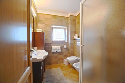 a bathroom with a toilet and a sink at Residence Grand Hotel SIVA - Adults Only in Santo Stefano dʼAveto