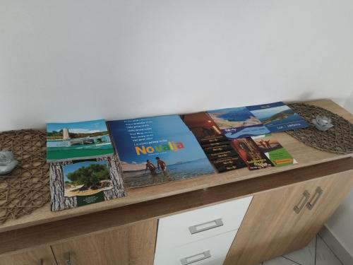 a wooden shelf with books on top of a table at CHERISH in Novalja