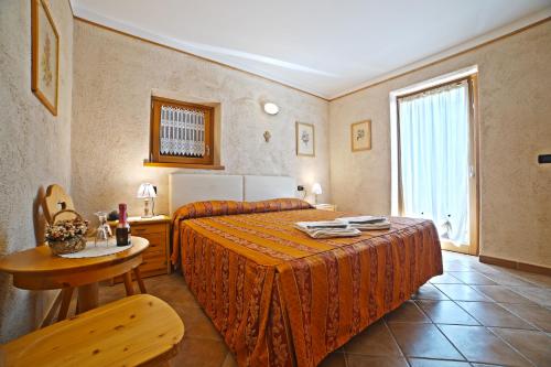 una camera con letto, tavolo e finestra di Residence Grand Hotel SIVA - Adults Only a Santo Stefano dʼAveto