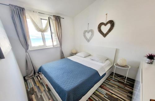 - une chambre avec un lit et deux cœurs sur le mur dans l'établissement Apartmani Nika, à Slatine