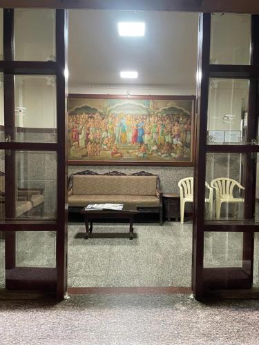 a room with a painting on the wall and a bench at Sri Durgamba Lodge in Bengaluru