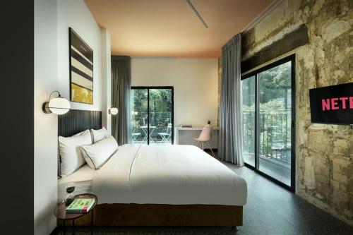 Cette chambre d'hôtel comprend un lit et un balcon. dans l'établissement Pixel Dizengoff Square - Smart Hotel by Loginn Tel Aviv, à Tel Aviv