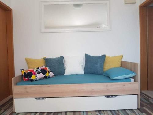 a couch with pillows on it in a room at Apartmani Nika in Slatine
