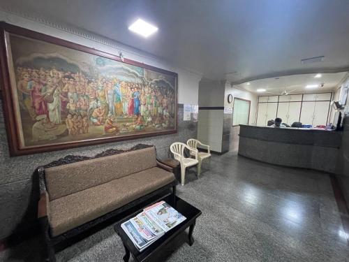 a living room with a couch and a painting on the wall at Sri Durgamba Lodge in Bengaluru