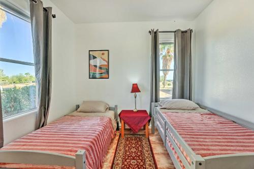 two beds in a room with a red stool at Cozy and Relaxing Eloy Apartment with Pool Access in Eloy