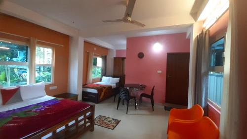 a bedroom with a bed and a table and chairs at Himadri munnar holidays in Munnar
