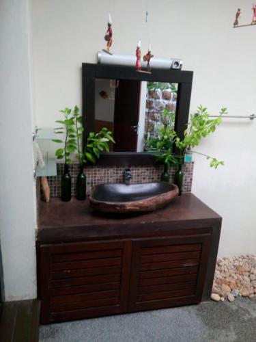ein Badezimmer mit einem Waschbecken und einem Spiegel auf einer Kommode in der Unterkunft BELINTA plage DUPLEX in Mahajanga