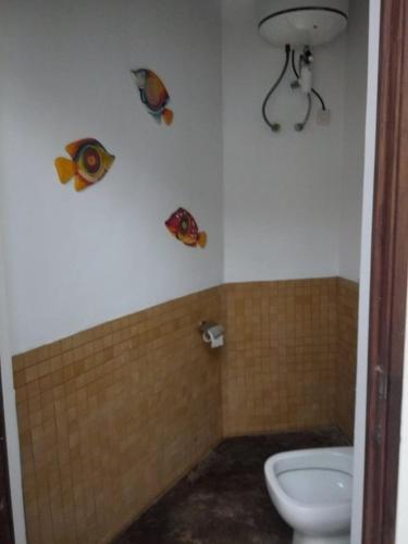 a bathroom with a toilet and fish on the wall at BELINTA plage DUPLEX in Mahajanga