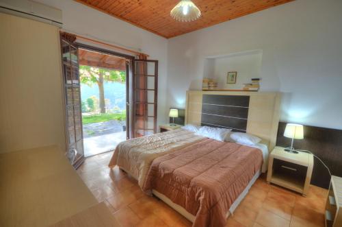 a bedroom with a large bed and a large window at Anna Pension in Liapades