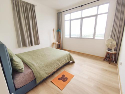 a bedroom with a bed and a window and a rug at Muji homestay kuching scenic view 2 bedrooms entire apartment in Kuching