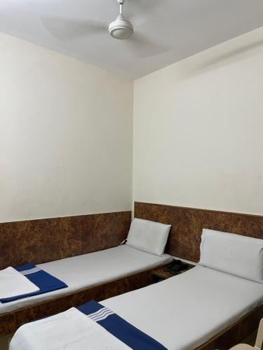 two beds in a small room with a ceiling at Sri Durgamba Lodge in Bengaluru