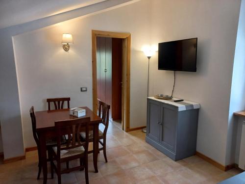 een eetkamer met een tafel en een televisie aan de muur bij Roccaraso Inn Blu in Roccaraso