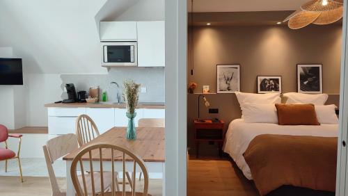 a kitchen and a bedroom with a bed and a table at Appart hôtel & Spa La Villa du Port in Vannes