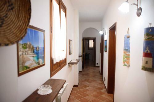 um corredor com uma mesa e pinturas na parede em Il Baglio di donna Rosa em Custonaci