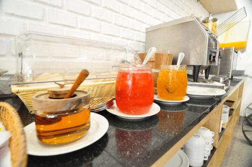 a kitchen counter with three jars of liquid at Forty Winks Phuket Hotel in Patong Beach