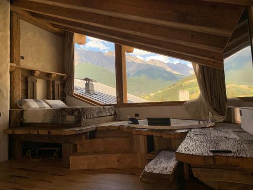 a bedroom with a large window with a view of mountains at AL BAIT DA LUCIA Bormio in Bormio