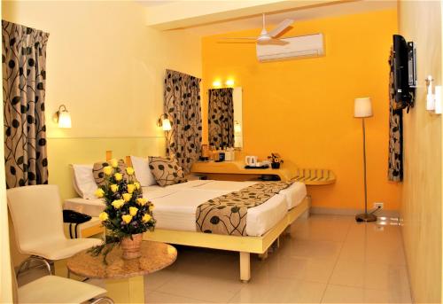 a hotel room with a bed and a chair at Hotel Pandian in Chennai