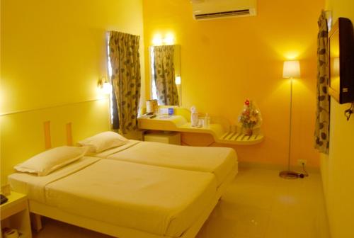 a bedroom with a bed and a sink and a mirror at Hotel Pandian in Chennai