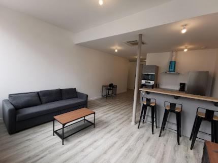 a living room with a couch and a table and stools at 10 rue Carnot in Montceau-les-Mines