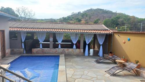 una casa con piscina frente a una casa en Casa Esmeralda para descanso, en Pirenópolis