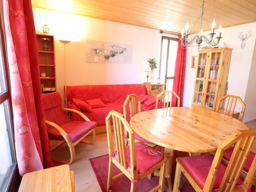 un salon avec une table et un canapé rouge dans l'établissement Charmant appart **, 6 pers, 2 balcons, prox pistes & village, parking gratuit - FR-1-342-147, à Arêches