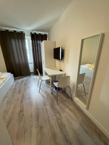 a small room with a desk and a mirror at Tyros Hotel und Gästehaus am Weidendamm in Hannover