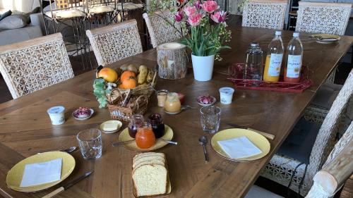 Una mesa de madera con platos de comida encima. en Le Clos Bô-m, en Marignieu